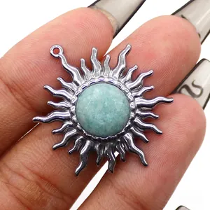 Dettaglio del ciondolo a girasole d'argento con pietra turchese tra le dita