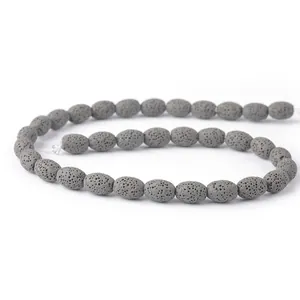 Macro-opname van ovale grijze lavasteenkralen met poreuze textuur voor DIY-sieraden