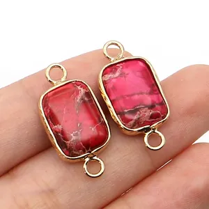 Macro view of rectangular red stone pendant connectors with dual gold loops for DIY jewelry