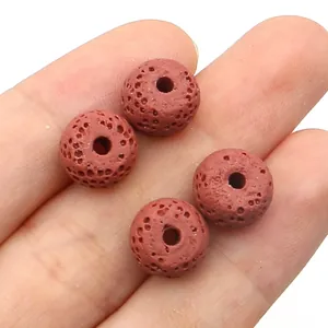 Macro detail of four reddish-brown volcanic lava stone beads with natural porous texture
