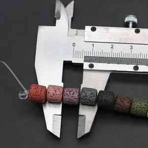 Macro de cuentas cilíndricas de piedra volcánica de colores midiendo 10mm con un calibre