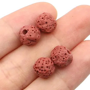 Macro-opname van vier rode poreuze lavastenen voor het maken van DIY-sieraden