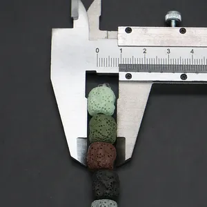 Macro view of porous lava stone beads in mixed colors with a size measurement caliper