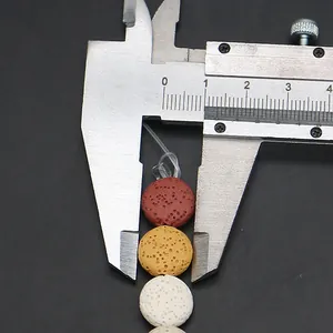 Macro shot measuring 10mm colorful porous volcanic lava beads with a digital caliper