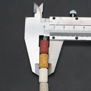Macro shot of colorful 10mm cylindrical volcanic stone beads measured with a caliper