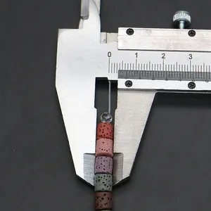 Detalle de la medición de cuentas de piedra volcánica natural de 8-10 mm con un calibre