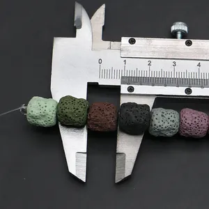 Macro view of 12mm porous lava stone beads measured with caliper on black background