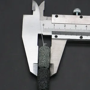 Makroaufnahme von 9mm porösen Lavasteinperlen, gemessen mit einem Messschieber