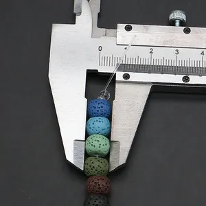Close-up of 8mm multicolored porous lava stone beads measured with a caliper
