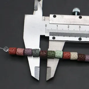 Primer plano de cuentas cilíndricas de piedra volcánica de 8mm medidas con un calibre