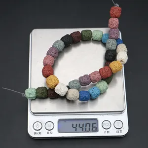 Close-up of multicolor square lava stone beads being weighed on a digital scale