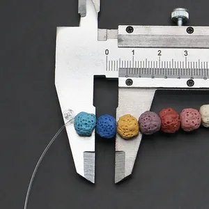 Macro-opname van het meten van 8mm kleurrijke lavasteen kralen met een schuifmaat