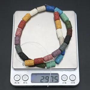 Detailed view of colorful cylindrical lava stone beads being weighed on a digital scale