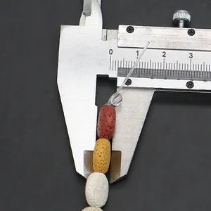 Detailed view of 10mm flat oval lava stone beads with natural pores and caliper measurement
