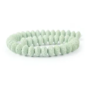 Macro detail of light green volcanic stone abacus beads showing natural porous texture