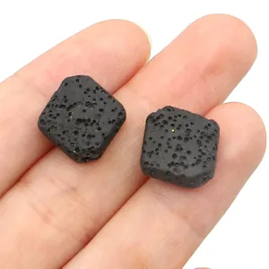 Detailed close-up of two square black lava rock beads with natural porous texture for DIY