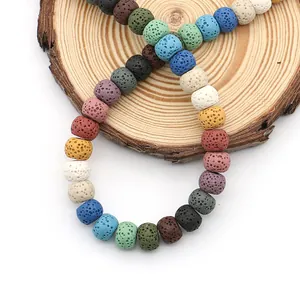 Colorful porous lava stone beads for diffuser jewelry making on wooden background