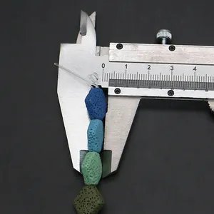 Macro detail of natural lava stone bead measured with a caliper showing porous texture
