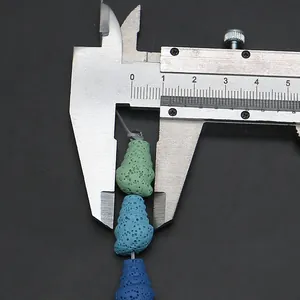 Macro shot of colorful cone-shaped lava stone beads measured with a silver caliper