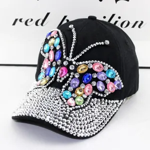 Detail einer schwarzen Jeans-Baseballkappe mit buntem Strass-Schmetterling und Kristallrand
