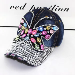 Detaillierte Makroansicht des bunten Strass-Schmetterlings auf verwaschener Denim-Kappe