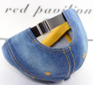 Detail der blauen Denim-Basecap mit Lederriemen und bronzefarbener Schnalle hinten