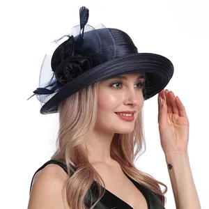 Detailed shot of dark blue fascinator hat with mesh flowers and feather accents