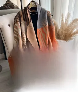 Detail of zebra pattern cashmere-like scarf with warm tones and fringe edges