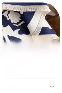 Close-up of thick blue and white floral fabric with delicate short fringe tassels
