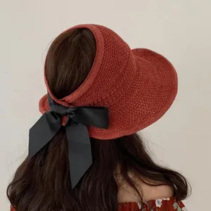Foldable rust red straw sun visor for women with large black decorative bow back view