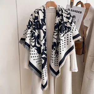Detail of polka dot rose cashmere feel scarf with fringe on a beige coat