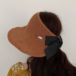 Women's foldable sun visor hat with large black bow and knit texture in caramel brown