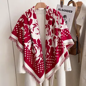 Red rose and polka dot cashmere-feel square scarf styled on a beige coat with fringe edges
