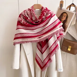 Detail eines rot-weißen Vintage-Schals mit floralem Muster und weichen Fransen
