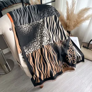 Detail of cashmere-like shawl with zebra print patchwork and delicate fringe trim