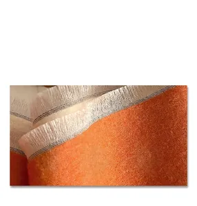 Macro shot of warm orange cashmere-like texture with fine weave and fringe edges