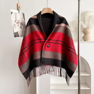 Detail of red and black plaid wool shawl featuring a button closure and thick tassels