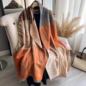Soft cashmere-like scarf with zebra and giraffe prints, fringe trim in bright orange hues