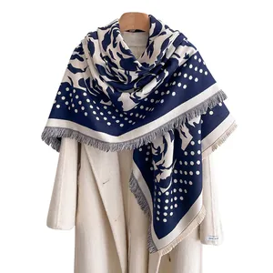 Navy blue and beige polka dot rose cashmere feel scarf with fringe on white coat