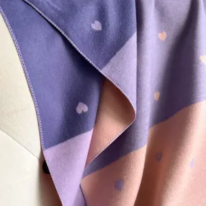 Detail of heart-patterned cashmere shawl showing plush texture and bicolor stitching
