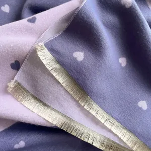 Detail shot of heart pattern scarf with delicate metallic fringe tassels and soft texture