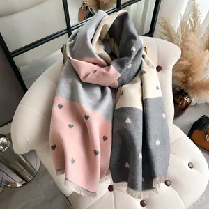 Detail of pink and grey heart pattern scarf with soft brushed texture and fringed edges