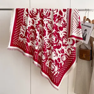 Detail of red rose pattern and polka dot borders on warm pashmina shawl with fringes