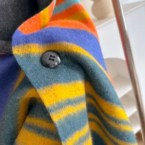 Colorful plaid wool scarf with orange and blue stripes and black button detail