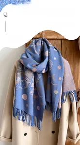 Detail of blue pashmina shawl with floral jacquard pattern and fine fringe trim