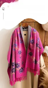 Detail of pink floral cashmere scarf with delicate tassels and soft knit texture