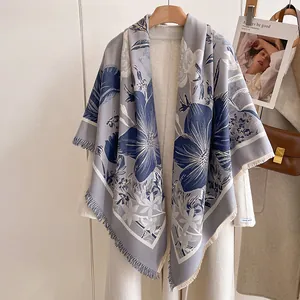 Détail d'un châle gris effet cachemire avec imprimé iris bleu et bords à franges