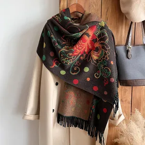 Detail of floral embroidery and fringe tassels on a dark brown cashmere shawl