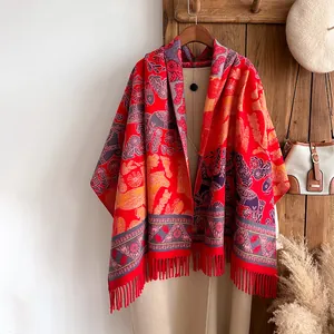 Detail of red floral horse pattern scarf with long fringe tassels on a wooden hanger