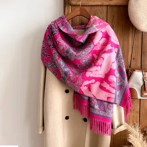 Detail of pink and grey floral cashmere shawl with fine fringe paired with wool coat